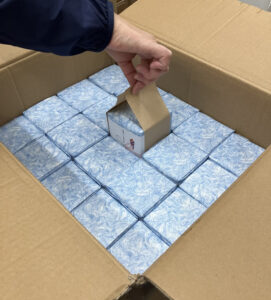 創業57年の福崎が行う、300個の記念品包装に『おび』を添える作業風景